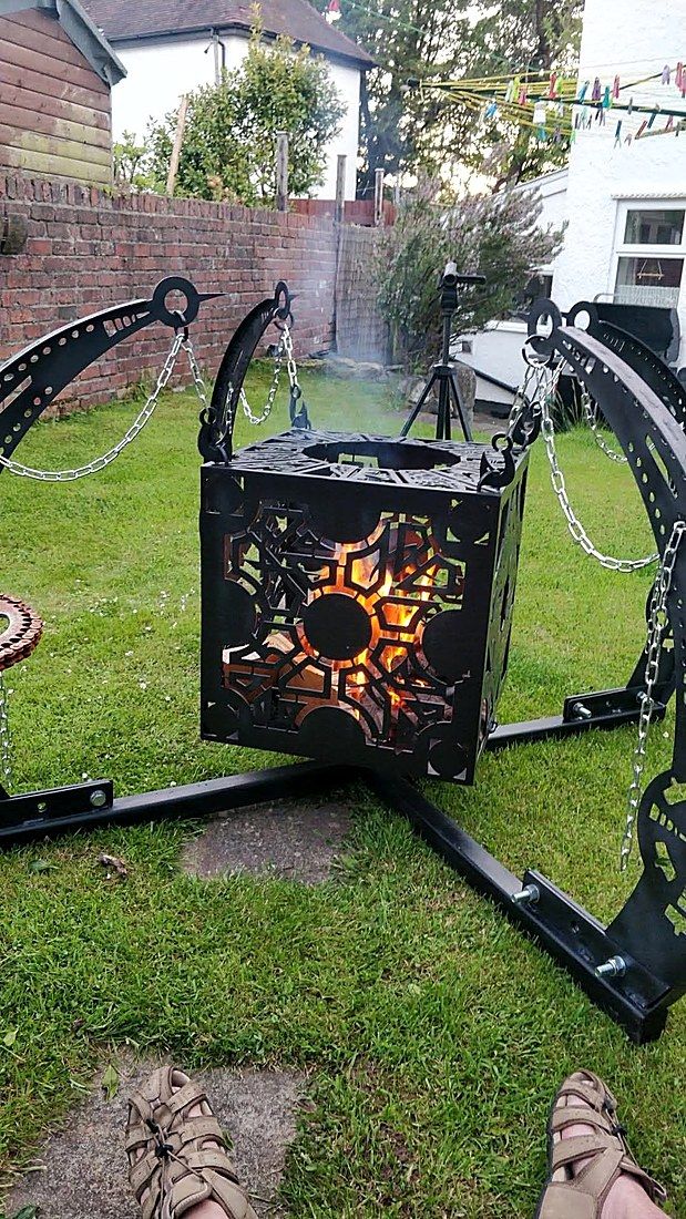 Ornate cube fire pit hung from the swing-arm rotisserie stand